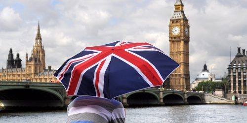 Big Ben and tourist with British flag umbrella in Southbank, London